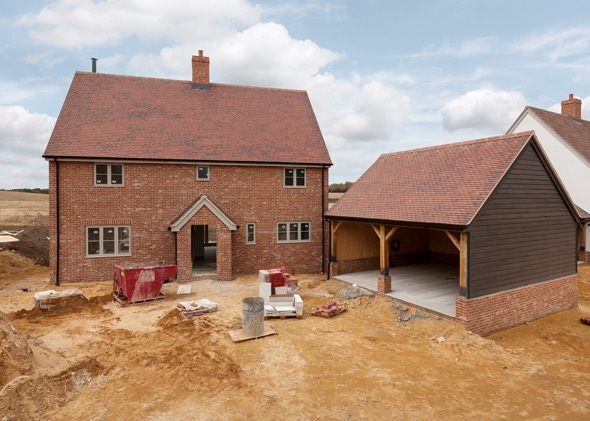 newly constructed house with a garage under construction in a residential area with clear skies and construction materials present showcasing modern architecture and design features