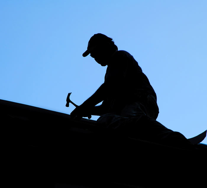 A silhouette of a man on a roof